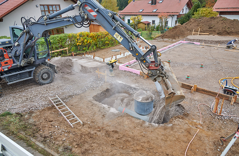 Bagger fülltauf Baustelle Baugrube mit Sand zur Verfüllung eines Flüssiggasbehälters,