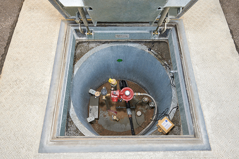 Offener Domschacht mit überfahrbarem Flüssiggasbehälter und angeschlossenen Mess- und Regelgeräten